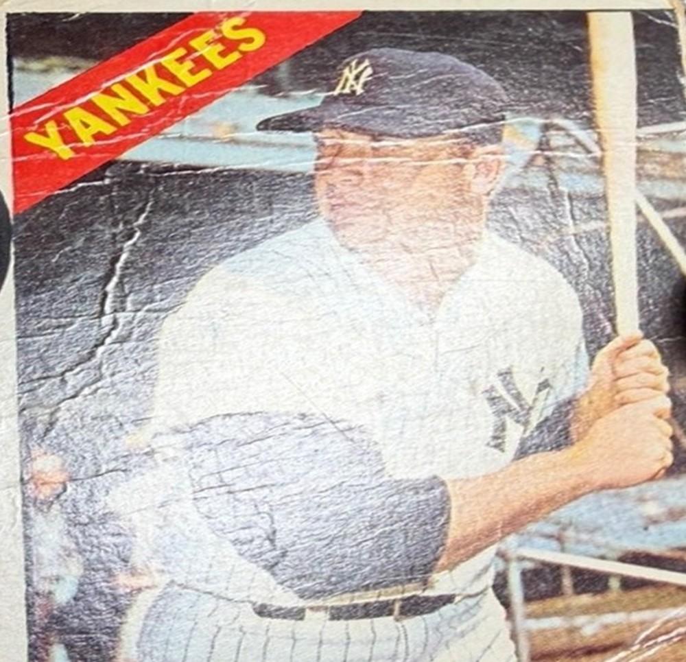 A Mickey Mantle card before restoration, cracked across the face and jersey